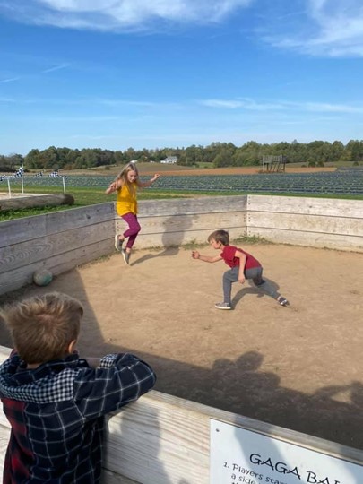 a boy and girl play a ball game inside a ring