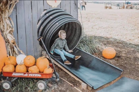 child coming out the end of an enclosed slide