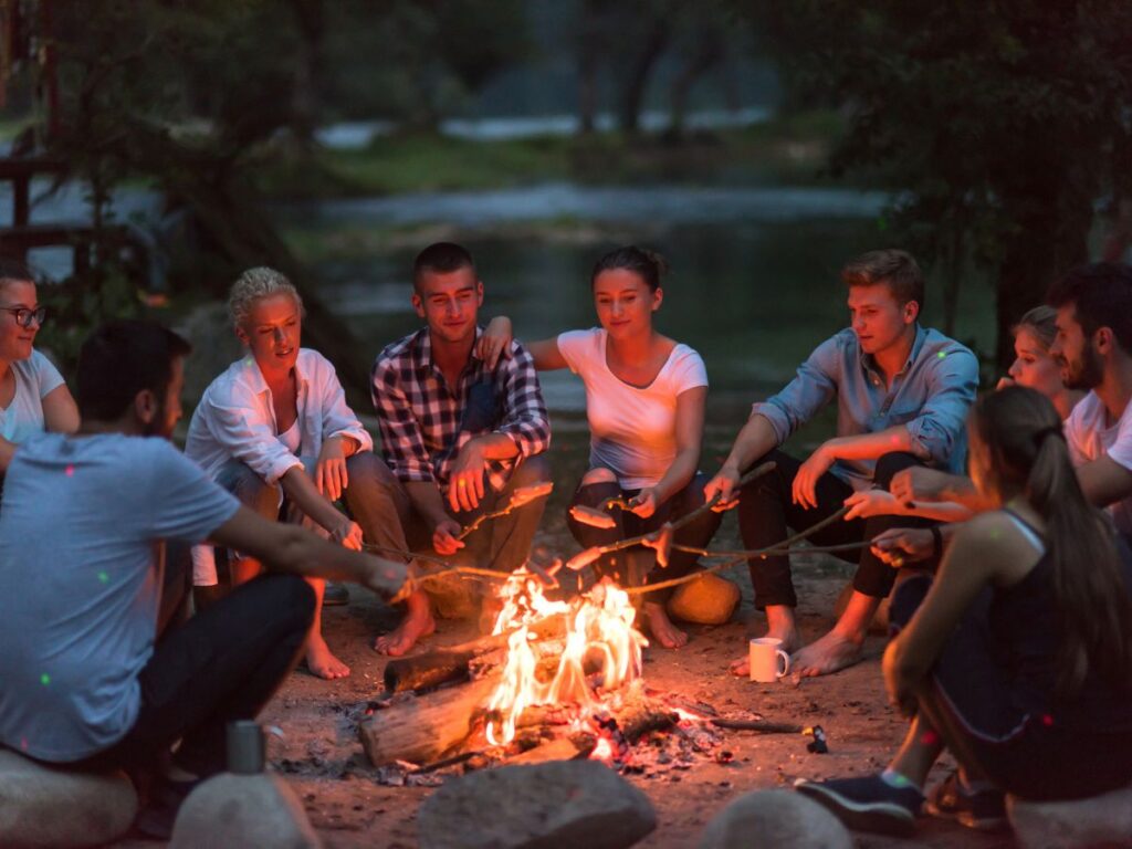 people roasting marshmallows over a campfire.